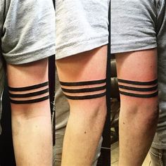 two men with black stripes on their arms and legs, both showing the same tattoo