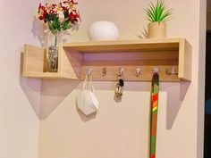 a wooden shelf with hooks and flowers on it