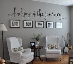 a living room with two chairs and pictures on the wall above them that says, find joy in the journey