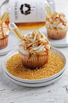 two cupcakes with caramel drizzle on top are sitting on a white plate