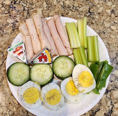 a plate with eggs, cucumbers, celery and meat on it