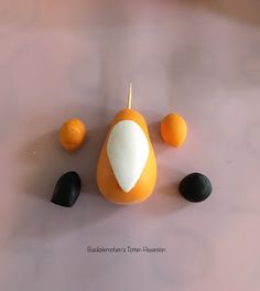 an orange and some black stones on a table