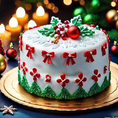 a decorated christmas cake sitting on top of a gold platter next to lit candles