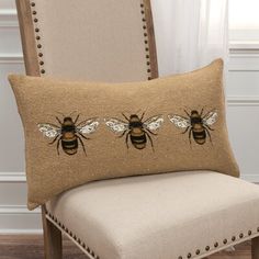 a chair with a pillow that has three bees on it