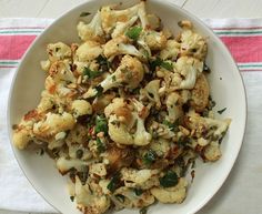 a white plate topped with cauliflower and herbs