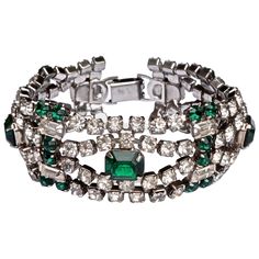 Beautiful silver tone bracelet featuring faceted emerald green and clear rhinestones, with a fold over clasp. The bracelet is slightly curved, and is in very good condition with all the original stones, circa 1950s. At a later date, the bracelet has been strengthened in the middle with soldering on the reverse. Measuring length 19.4cm / 7.64 inches by width 2.4cm / .94 inch. This lovely vintage bracelet would look stunning and glamorous worn to a special occasion.