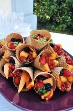 a plate topped with cones filled with fruit