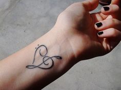 a woman's arm with a tattoo on it that has the letter e in cursive writing