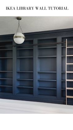 an empty room with blue bookcases and a light fixture hanging from the ceiling