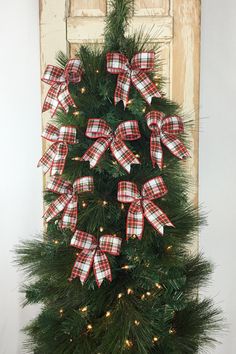 a christmas tree decorated with red and white bows