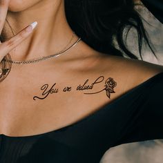 a woman with a rose tattoo on her chest and the words you are loved written in cursive font