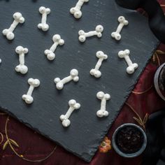 small white bones and crossbones are arranged on a slate board