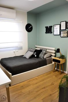 a bed room with a neatly made bed and a clock on the wall above it