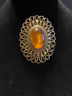 "Vintage Oval Amber Color Gem Brooch - has 3 layers of ornate gold color borders - it does not close very tight but it might on clothes - normal wear and scratches - may have slight discoloration in places due to age - 2.5\" x 2\"" Antique Gold Oval Brooch, Antique Gold Oval Brooches, Gold Filigree Oval Brooch, Gold Oval Filigree Brooch, Oval Gold Filigree Brooch, Ornate Gold Cabochon Brooches, Antique Gold Brooch With Oval Cabochon, Vintage Gold Brooch With Cabochon, Antique Gold Oval Cabochon Brooch