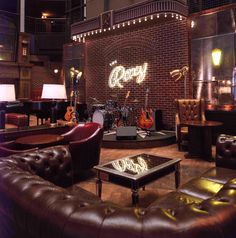 a living room filled with lots of furniture next to a fire place and piano in the corner