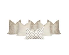 four pillows with different patterns on them, one in white and the other in beige