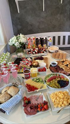 a table filled with food and drinks on top of a white table covered in plates