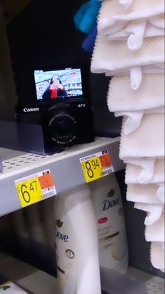 there is a camera that is on the shelf in the store, next to towels