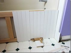 the bathroom is being remodeled with white tile and wood trimmings on the floor