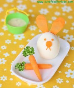 a plate with carrots and an egg in the shape of a bunny