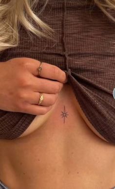 a close up of a person's stomach with a star tattoo on her left side