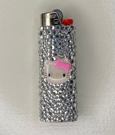 a hello kitty cell phone case is shown on a white surface with silver sequins