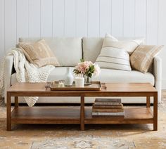 a living room with a couch, coffee table and pillows