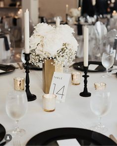 a table with candles, plates and flowers in vases on top of the table