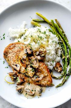 chicken with mushrooms, asparagus and rice on a white plate