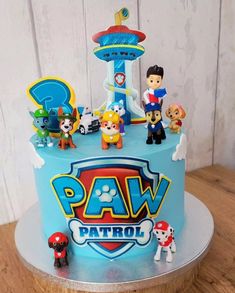 a blue cake with paw patrol figures on it