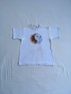 "vintage 1990s t-shirt Fruit Of The Loom Heavy cotton single stitch sleeve/hem white tee w/multi color yin yang symbol art god vintage condition, light stains/paint throughout, see photos label size M, see below measures, lying flat, shoulder-16\" sleeve-6 1/2\" chest-19\" length-25\"" Hippie Cotton T-shirt For Streetwear, Hippie Style Screen Print T-shirt, Cotton Hippie T-shirt With Screen Print, Hippie Cotton Screen Print T-shirt, Hippie Cotton T-shirt With Screen Print, White Short Sleeve T-shirt For Festivals, White Crew Neck Hippie T-shirt, White Hippie Crew Neck T-shirt, 90s Style Short Sleeve Festival T-shirt