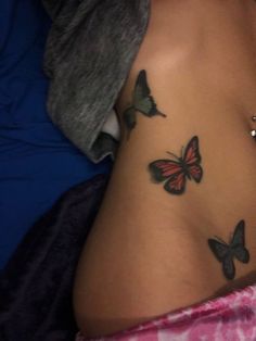 a woman's stomach with three butterflies on her side and the bottom part of her belly