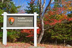 the sign for arcadia national park is in front of some trees with leaves on them