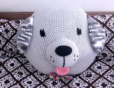 a crocheted stuffed dog with a bow tie on it's head sitting on a bed