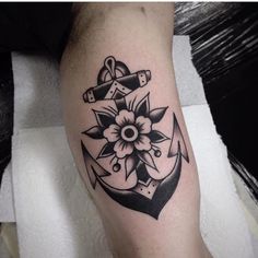 an anchor and flower tattoo on the left leg is shown in black and grey ink