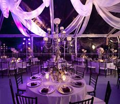 the tables are set up with white linens and candles for an elegant wedding reception