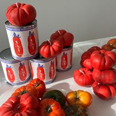 tomatoes and other vegetables on a table with tins in the shape of pumpkins