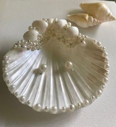 two seashells are sitting on a table with pearls