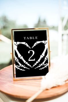 the table numbers are placed on top of a wooden plate with feathers in front of it