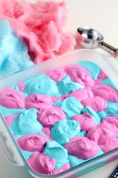 blue and pink cake batter in a glass pan with spoons next to it on a white surface