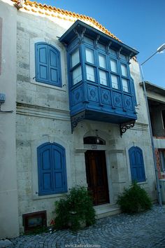 an old building with blue shutters and windows