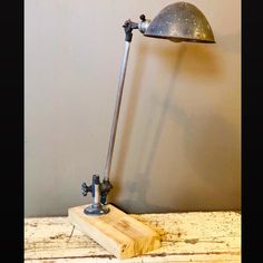 a desk lamp sitting on top of a wooden table next to a wall mounted light