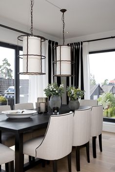 a dining room table with chairs and vases on it