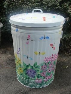 a white trash can sitting on top of a sidewalk