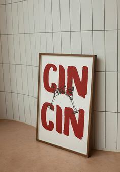 a red and white sign that says gin on it next to a wall with tiles