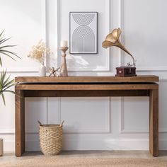 a wooden table with a lamp on top and a basket under the table next to it