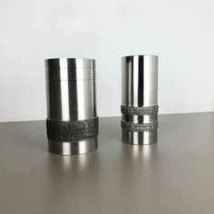 two metal cups sitting on top of a table