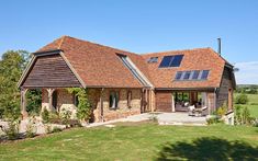 a house with a large lawn in front of it and lots of windows on the roof