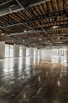 an empty warehouse with lots of windows and lights on the ceiling is pictured in this image