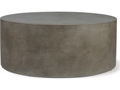 a round concrete coffee table sitting on top of a white floor